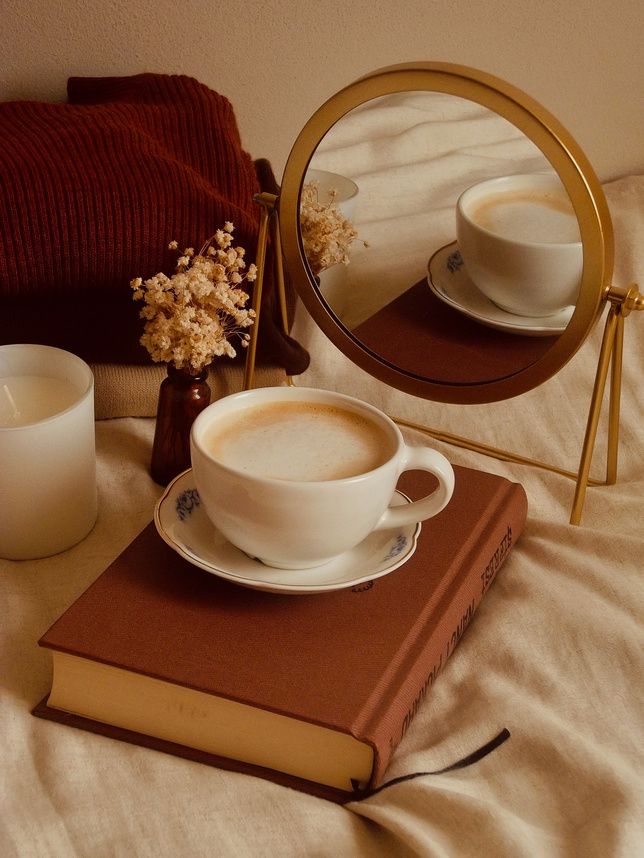 White Ceramic Teacup on Top of Book